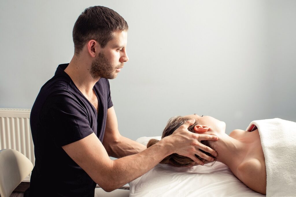 A massage therapist gently supporting and stretching a client's neck and head during a relaxation therapy session.